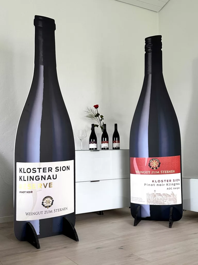 Riesige Weinflaschen als POS-Lösungen für das Weingut zum Sternen – auffällige Verkaufsförderung am Point-of-Sale.